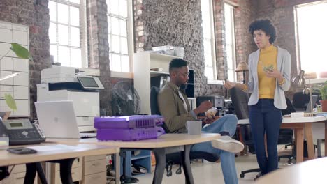 focused diverse colleagues discussing work and having lunch in office in slow motion