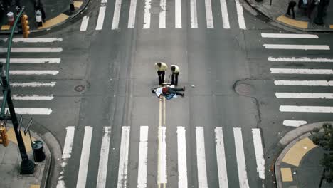 two workers in yellow vests direct traffic in a busy downtown intersection. cars pass by as they help maintain safety and order on the road. the scene captures urban life in action.