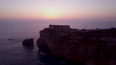 sunset over a coastal cliff with lighthouse