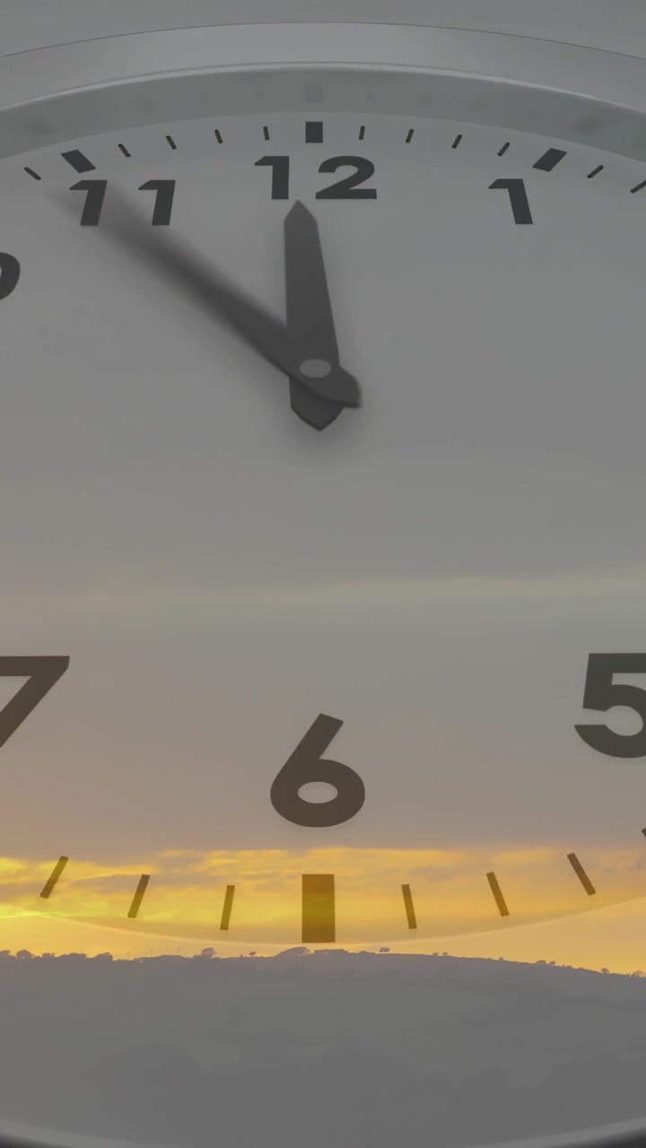 Vertical video: Clock hands starting right sweeping clockwise showing time lapse over golden sky