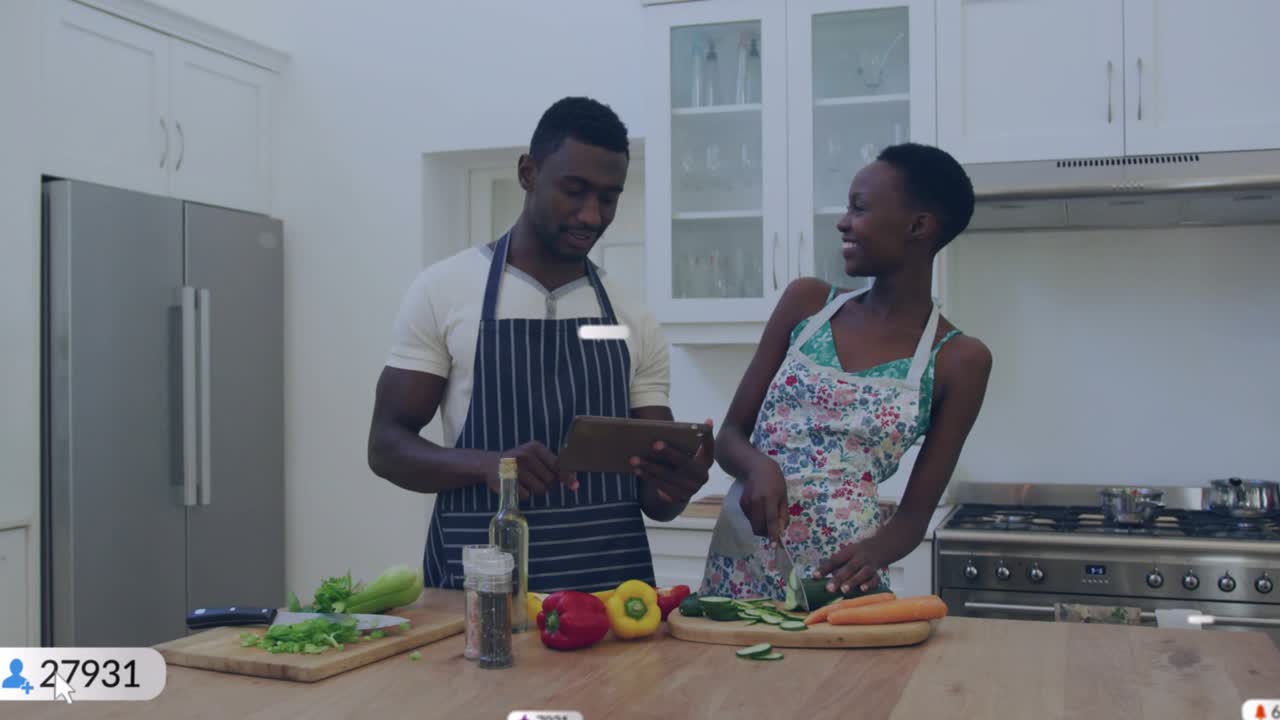 Couple chopping vegetables in kitchen while tapping tablet, monitoring subscriber counts rising