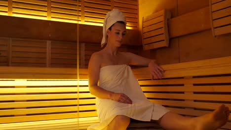 beautiful adult woman walking into a modern finnish sauna