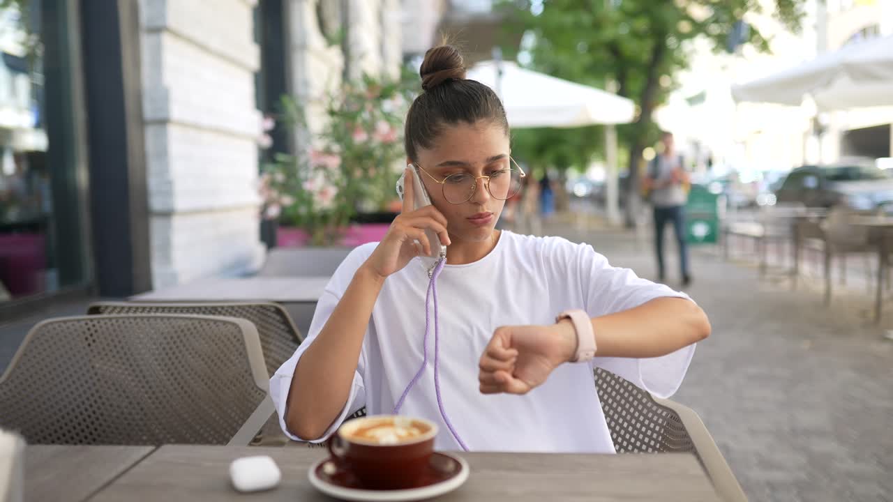 una mujer joven hablando por teléfono en un café.