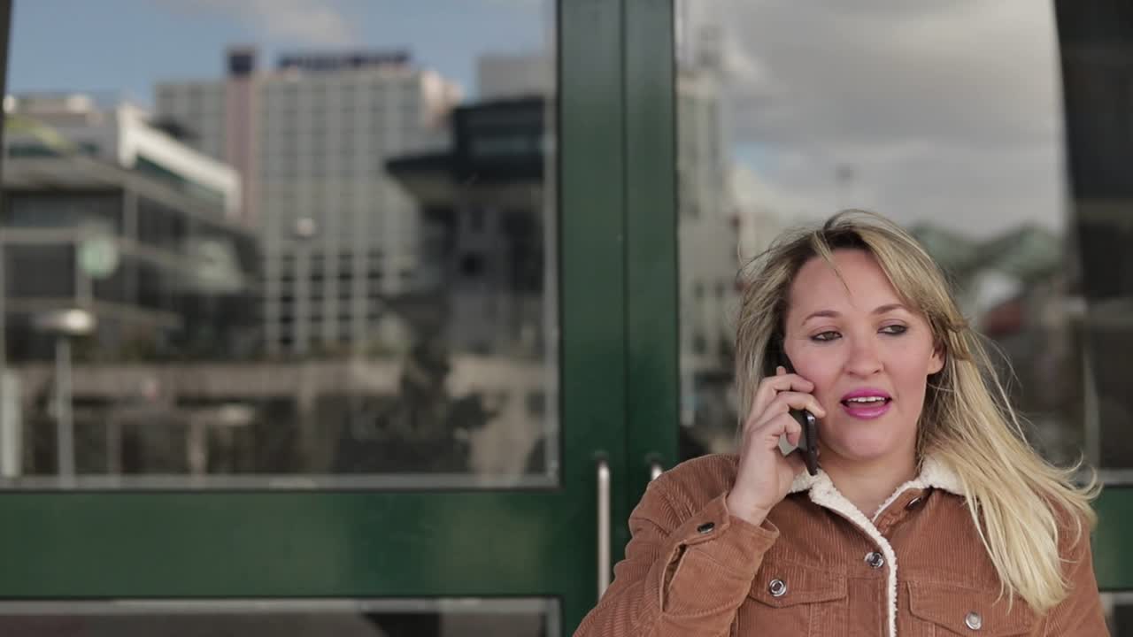 mujer de mediana edad sonriendo hablando en el teléfono inteligente al aire libre