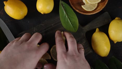 men hands shift sliced lemon from the cutting board.