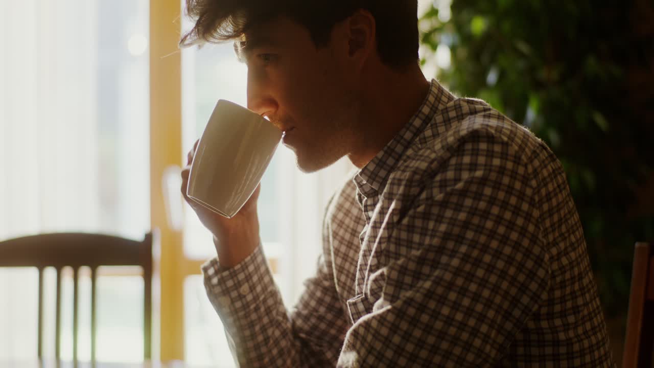 창문 에서 커피를 마시는 남자