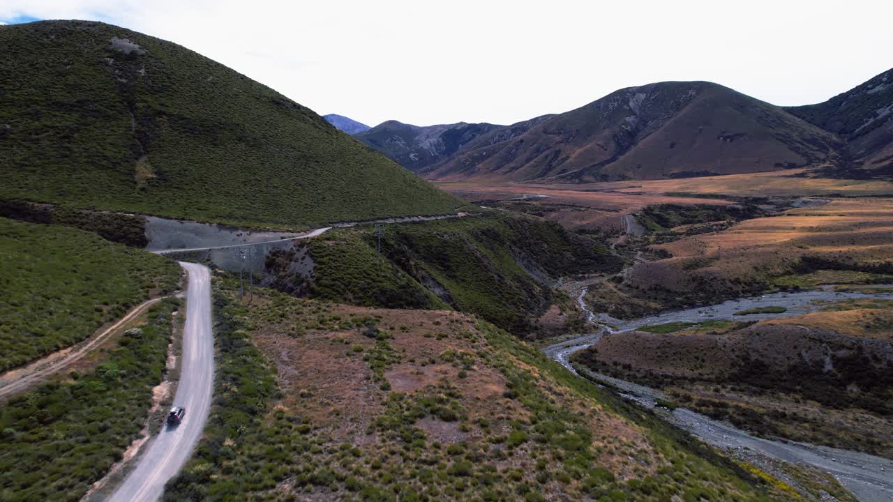 Drone tracking a vehicle driving in the wilderness of Canterbury, in cloudy NZ