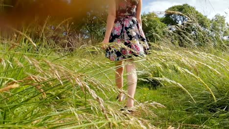 mujer caminando por el campo verde 4k