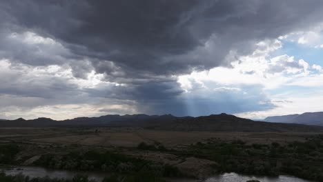 Wide-drone-shot-of-light-rays-shining-through-storm-clouds