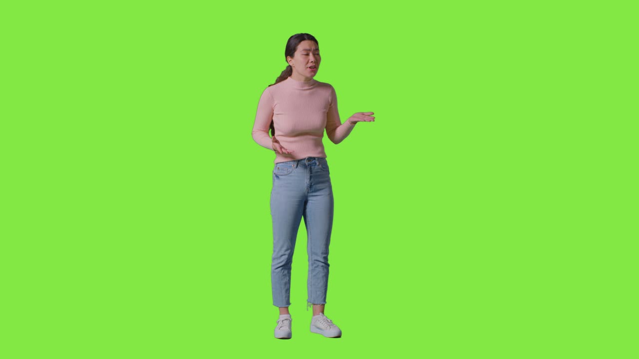 Full Length Studio Portrait Of Frustrated Angry Woman Shouting Off Camera Standing Against Green Screen