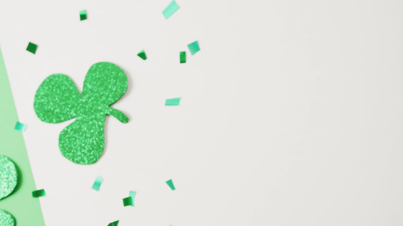 Video of st patrick's green shamrock leaves with copy space on green to white background