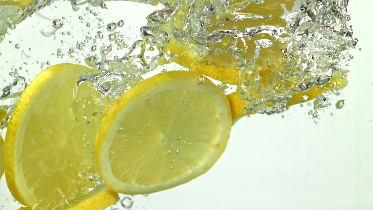 Lemon Slices Falling into Water with Bubbles in Slow Motion