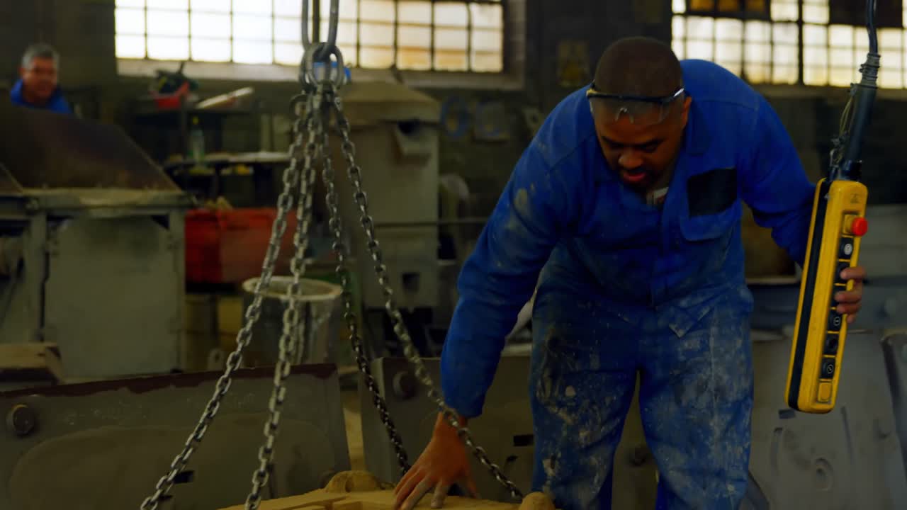 Worker using overhead crane in foundry workshop 4k