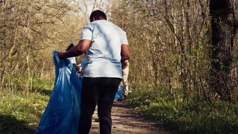 Diverse-activists-group-using-claw-tools-to-grab-trash-and-plastic