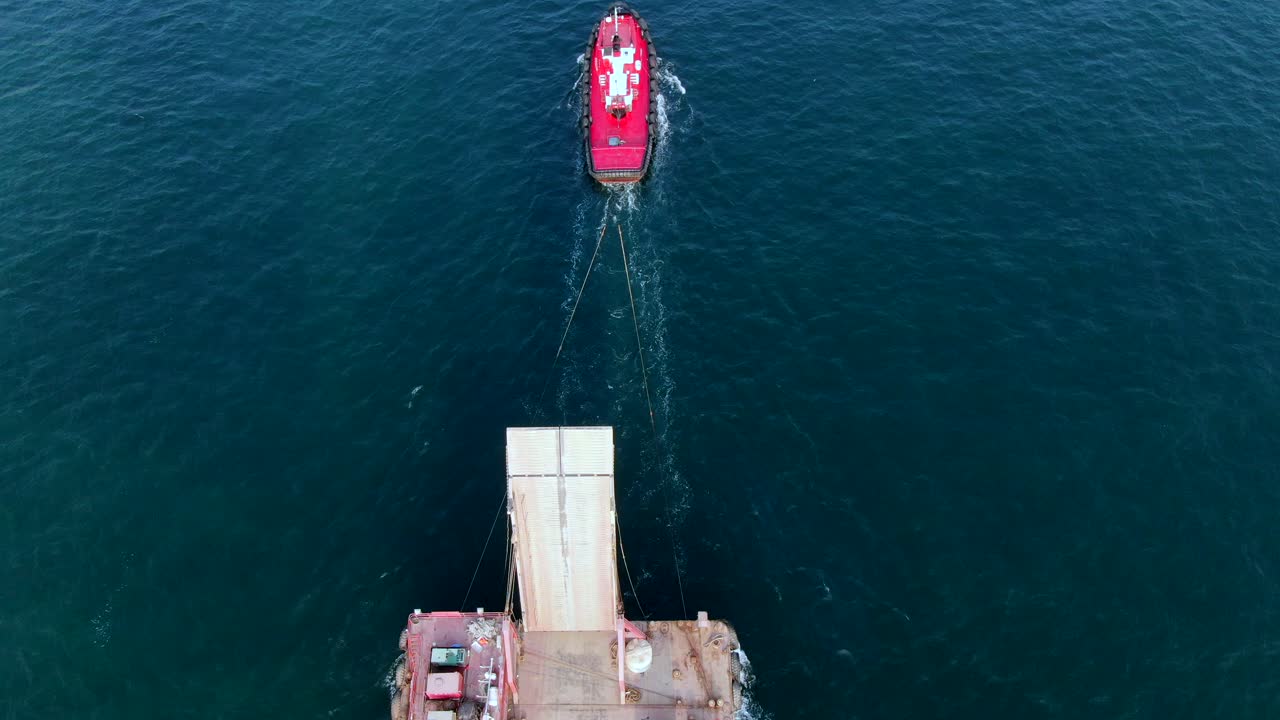 barcaza cargada con camiones hormigonera tirada al puerto por un remolcador en la bahía de hong kong, vista aérea