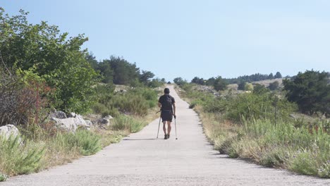 Un-Hombre-Solo-Caminando-En-Las-Montañas-Con-Bastones-De-Trekking