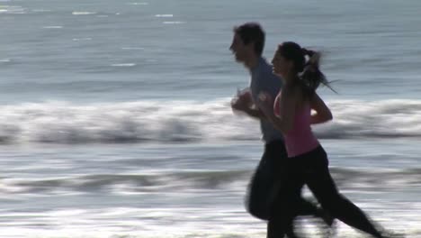 two people jogging along a beach