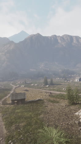 a misty mountain valley with a farmhouse and dirt road