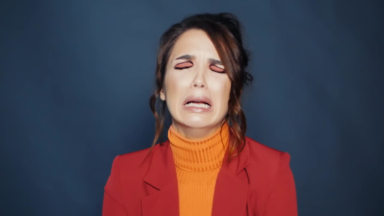chica morena con ojos de avellana y maquillaje profesional llorando con la boca abierta