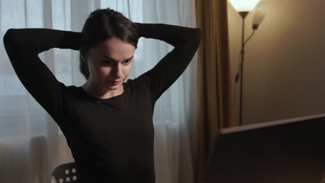 mujer atando el cabello antes de comenzar a trabajar en su portátil - de cerca