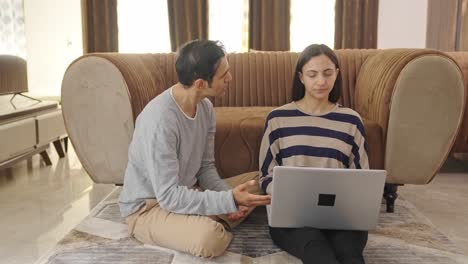 indian wife working on laptop, husband shouting on her