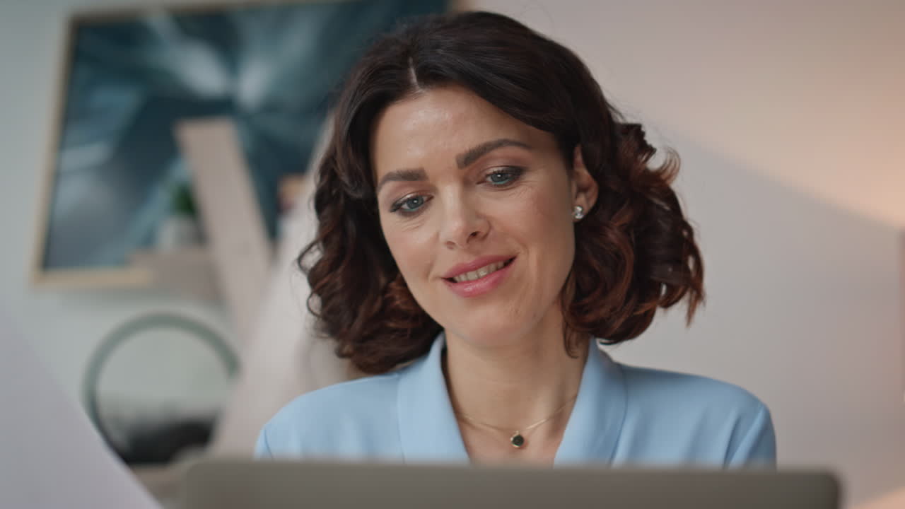 Primo piano: donna d'affari che guarda lo schermo del laptop mentre crea un progetto online in ufficio.