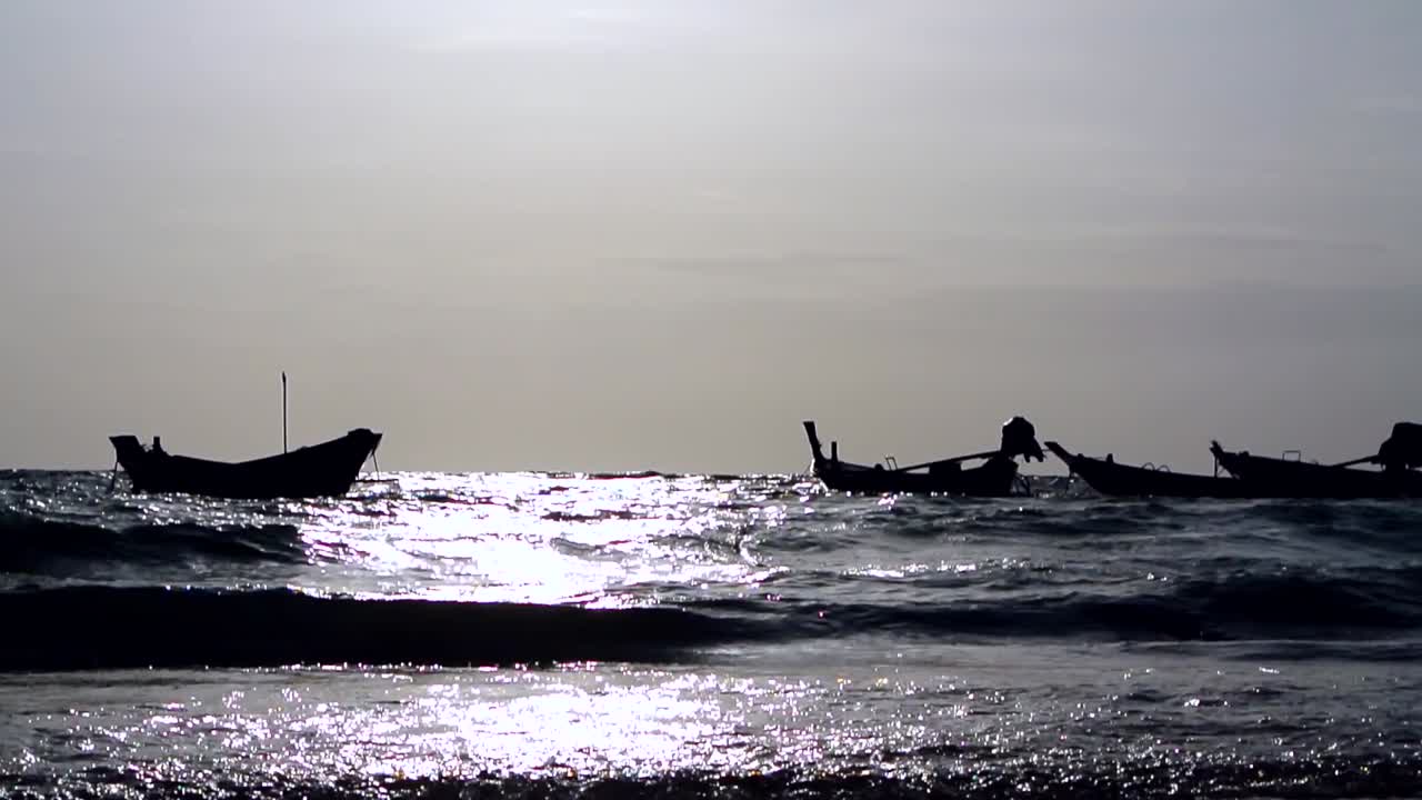 파도 사이 열대 섬 해안에 정박한 섬 어선