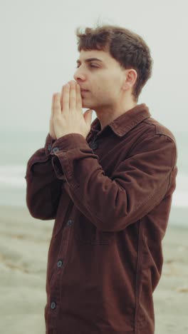 intense moment of religious prayer for a man at the beach