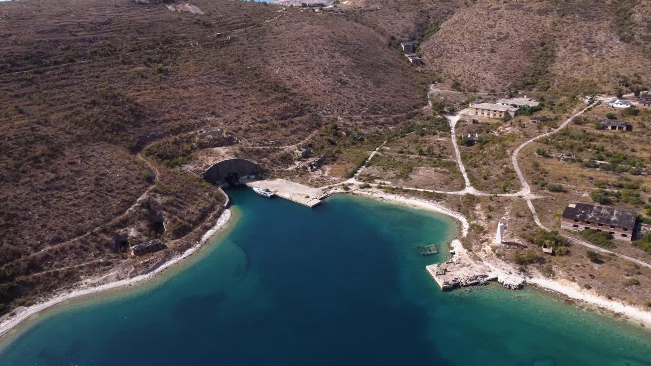 sobrevuelo aéreo sobre una hermosa playa albanesa con estructuras comunistas abandonadas