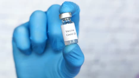 hand holding covid-19 vaccine vial