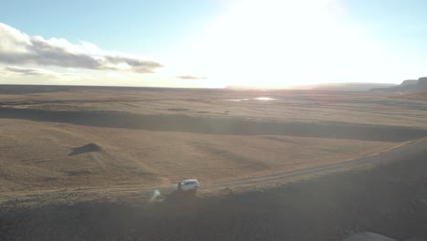 Toma-Orbital-Aérea-De-Un-Auto-Solitario-Estacionado-En-Un-Vasto-Paisaje