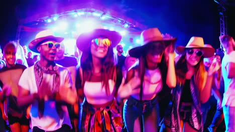 a group of people enjoying a lively night party or concert with colorful lights