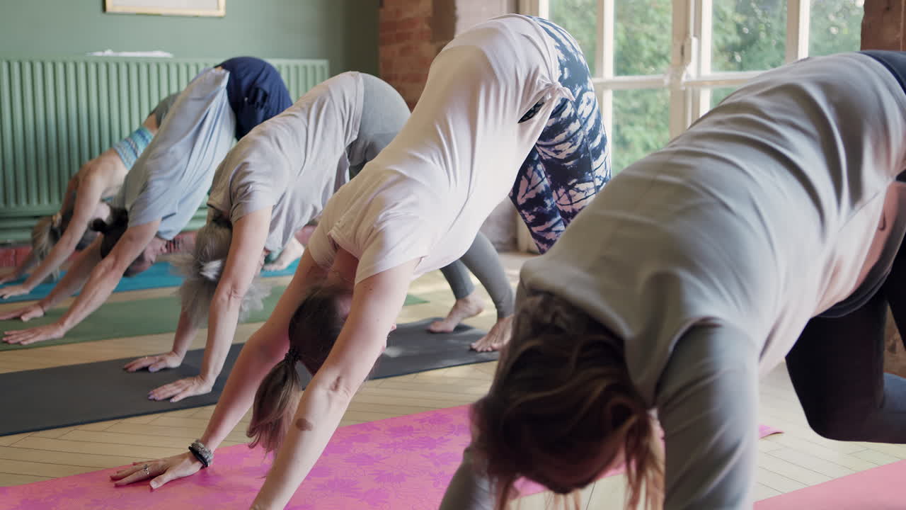 Group yoga class practicing downward dog pose