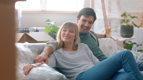 nueva casa, cajas y pareja relajarse en el sofá juntos