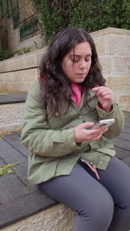 young adult woman using smartphone outdoors