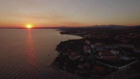 Toma-Aérea-Del-Complejo-Griego-En-La-Costa-Del-Mar-Al-Atardecer