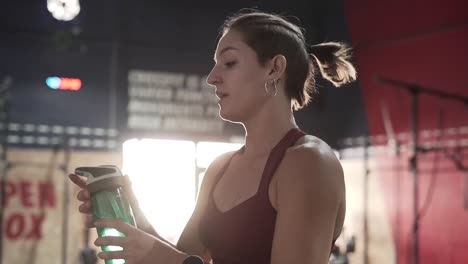 mujer bebiendo agua después del entrenamiento