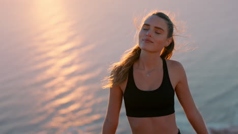 healthy woman on mountain top looking at calm view of ocean at sunset girl standing on edge of cliff enjoying freedom contemplating journey to summit