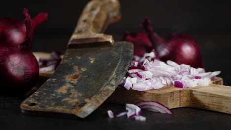 red onion on cutting board with big knife rotates slowly.