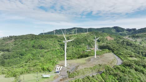 Wind-turbines-adorning-the-rolling-hills,-long-shot,-aerial-drone-movement-from-right-to-left