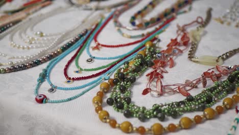 a selection of colorful necklaces, bracelets, and earrings for sale at a craft fair