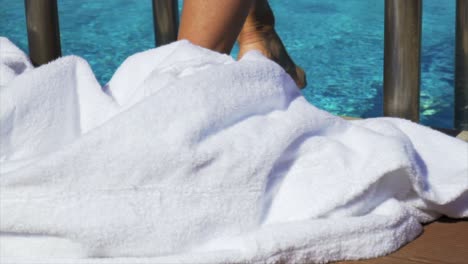 woman dropping her dressing gown to step into a swimming pool