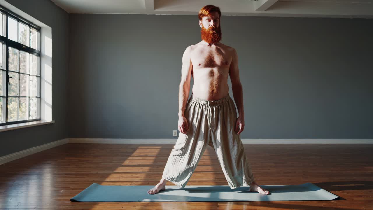 Man practicing yoga poses in a studio