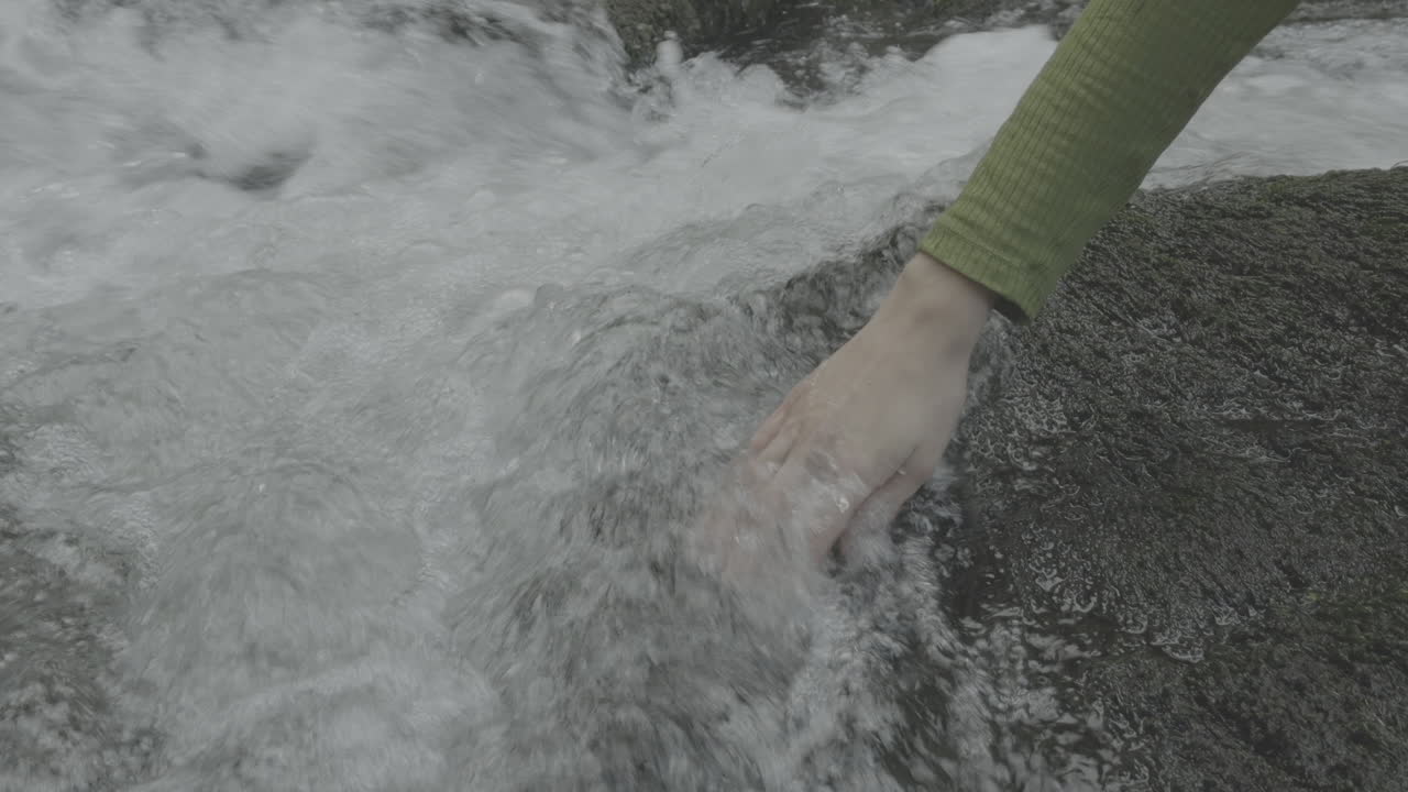 Person touching water in a stream