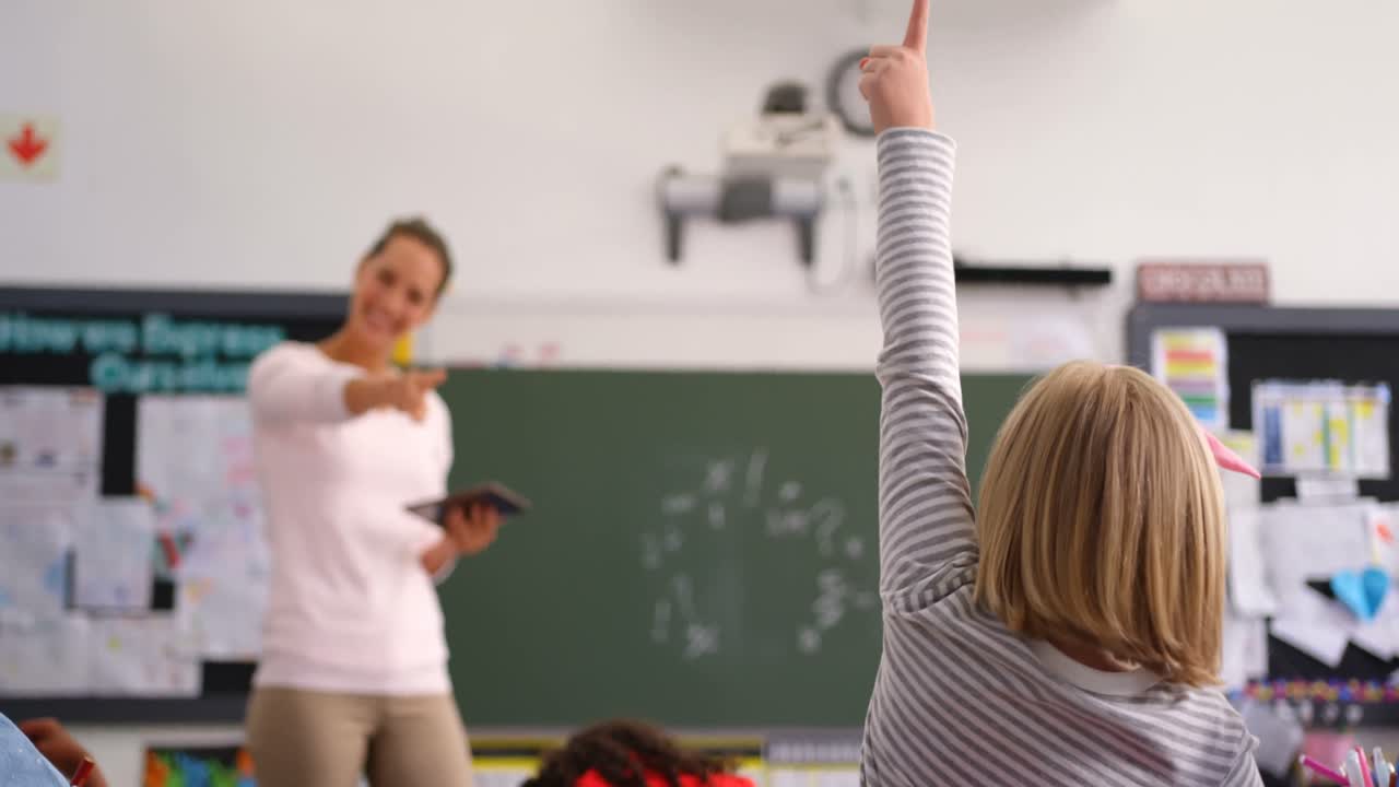 vista trasera de una colegiala levantando la mano en el aula 4k