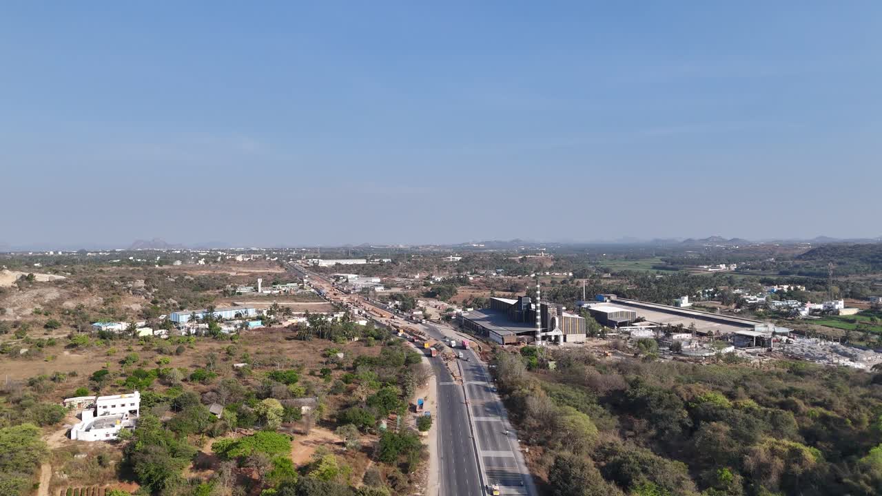 Aerial video of Developing India: Road Infrastructure Factories Corporate videos showcasing logistics, supply chains, or industrial operations. an active industrial area in the highway