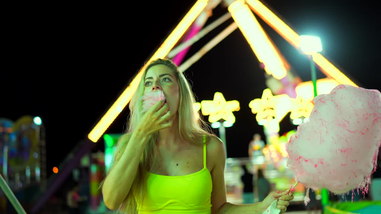 Woman Enjoying Cotton Candy at a Carnival
