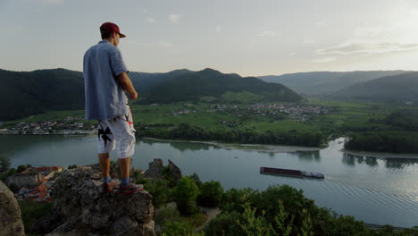 cool guy, mountain landscape, river danube in background, sunny weather, travelling man, hike trail path to the horizon, sunny valley austria, travel freedom, free living, digital detox relaxation