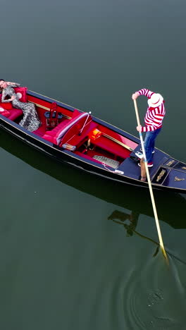 gondolier putting gondola through river. aerial view of gondolier carries tourists on gondola