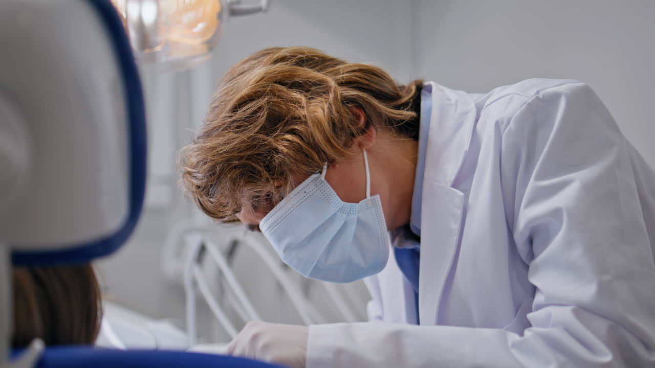 Doctor start dental examination in clinic wearing mask closeup. Woman dentist